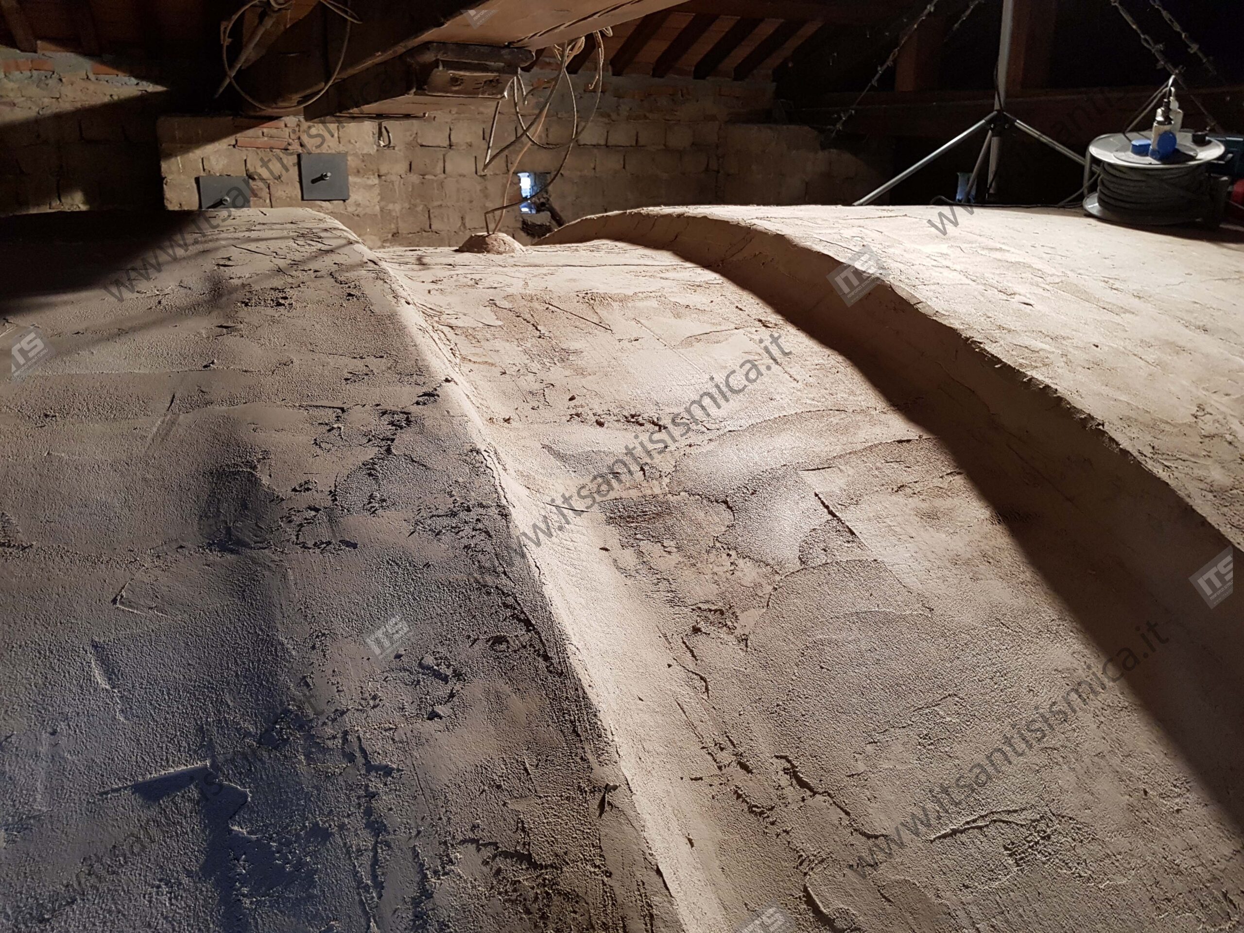 Estradosso delle volte a lavorazione ultimata, visto dal sottotetto, con la struttura lignea di copertura e le piastre di ancoraggio a parete